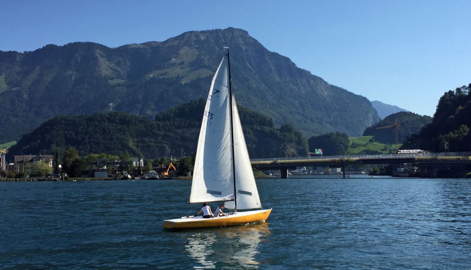 Segelboot der Segelschule Stansstad vor dem Bergpanorama